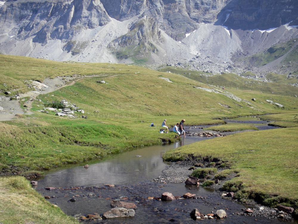 Guide des Hautes-Pyrénées - Cirque de Troumouse - Rivière bordée de pâturages (pelouses), montagnes du cirque en arrière-plan ; dans le Parc National des Pyrénées