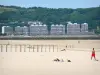 Hendaye - Holidaymakers on the sandy beach; buildings of the Spanish coast in the background