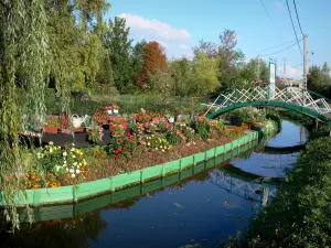 Hortillonnages von Amiens - Blühender Garten (Blumen) am Rande des Wassers, kleiner Steg überspannend den Kanal