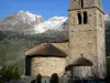 Iglesia Mère-Église de Saint-Disdier - Madre-Iglesia o capilla Gicons estilo románico con techo de paja y pizarra, y montañas de cumbres nevadas Dévoluy