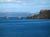 Île de Porquerolles - Mer méditerranée, rochers, côte sauvage de l'île, littoral et collines du massif des Maures au loin, nuages dans le ciel