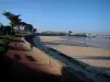 Île de Ré - La Flotte : promenade longeant la plage de sable, maisons et port du village (station balnéaire) en arrière-plan