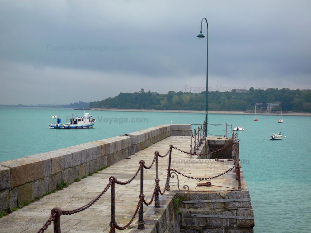 Guide de l'Ille-et-Vilaine - Paysages du littoral de Bretagne - Cancale : jetée agrémentée d'un lampadaire, bateaux sur la mer, côte et ciel orageux