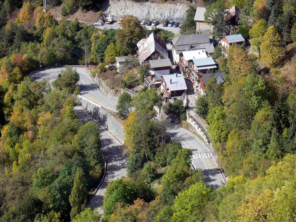 Guide de l'Isère - Oisans - Route de l'Alpe d'Huez : route en lacet, chalets et arbres