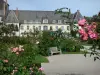 Jardins dos Valloires - Rosas em primeiro plano, jardim de rosas (rosas), banco e abadia cisterciense de Valloires