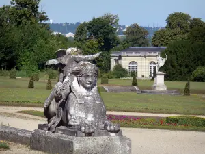 Kasteel van Champs-sur-Marne - Castle Park: Sphinx standbeeld op de voorgrond, bloembedden, gazons, struiken, bomen en oranjerie