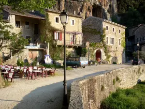 Labeaume - Restaurant terrace and houses of the village at the foot of the cliffs of the Balm gorges