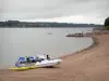 Lac de Pareloup - Plateau du Lévézou : retenue d'eau et plage de sable avec pédalos et bateaux