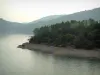 Lac de Saint-Cassien - Plan d'eau, rive avec de la végétation et des arbres, collines couvertes de forêts en arrière-plan