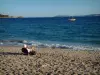 Landscapes of the French Riviera coast - Sandy beach of Cavalière with a tourist, the Mediterranean Sea, a sailboat and the wild coasts