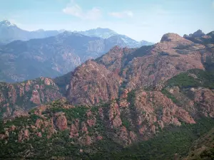 Landscapes of the inland Corsica - Mountains (red granite rock) with snowy summit of the Monte Cinto mountain in background