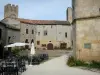 Larressingle - Terraço de café, torre com ameias e fachadas de casas da vila fortificada medieval