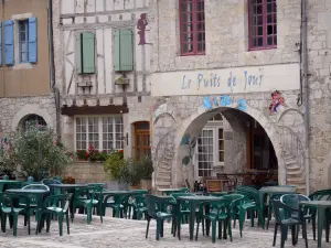 Lauzerte - Medieval Bastide fortified town: facades of houses and café terrace of the Place des Cornières square