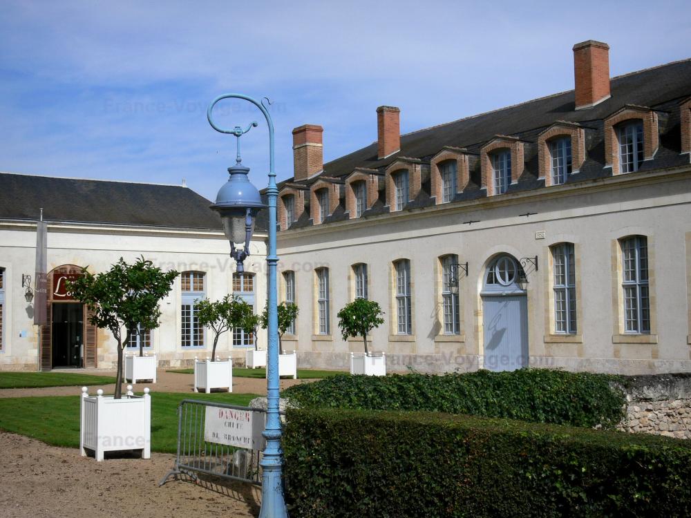 Guide du Loiret - Châteauneuf-sur-Loire - Anciennes écuries du château abritant le musée de la Marine de Loire, arbres en pots et lampadaire