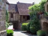 Loubressac - Maisons du village médiéval avec arbustes et fleurs, en Quercy