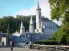 Lourdes - Domaine de la Grotte (sanctuaires, cité religieuse) : pont avec vue sur les tourelles et le clocher de la basilique de l'Immaculée Conception (basilique supérieure) de style néogothique