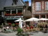 Lyons-la-Forêt - Terraza del café, las decoraciones florales (flores) y las fachadas de las casas en el pueblo