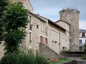 Le Malzieu-Ville - Tour de Bodon abritant l'office de tourisme, façade de la mairie du Malzieu (ancienne chapelle des Pénitents blancs) et parterres de fleurs