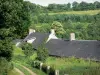 Mancelles Alpen - Hausdächer umgeben von Grün; im Regionalen Naturpark Normandie-Maine