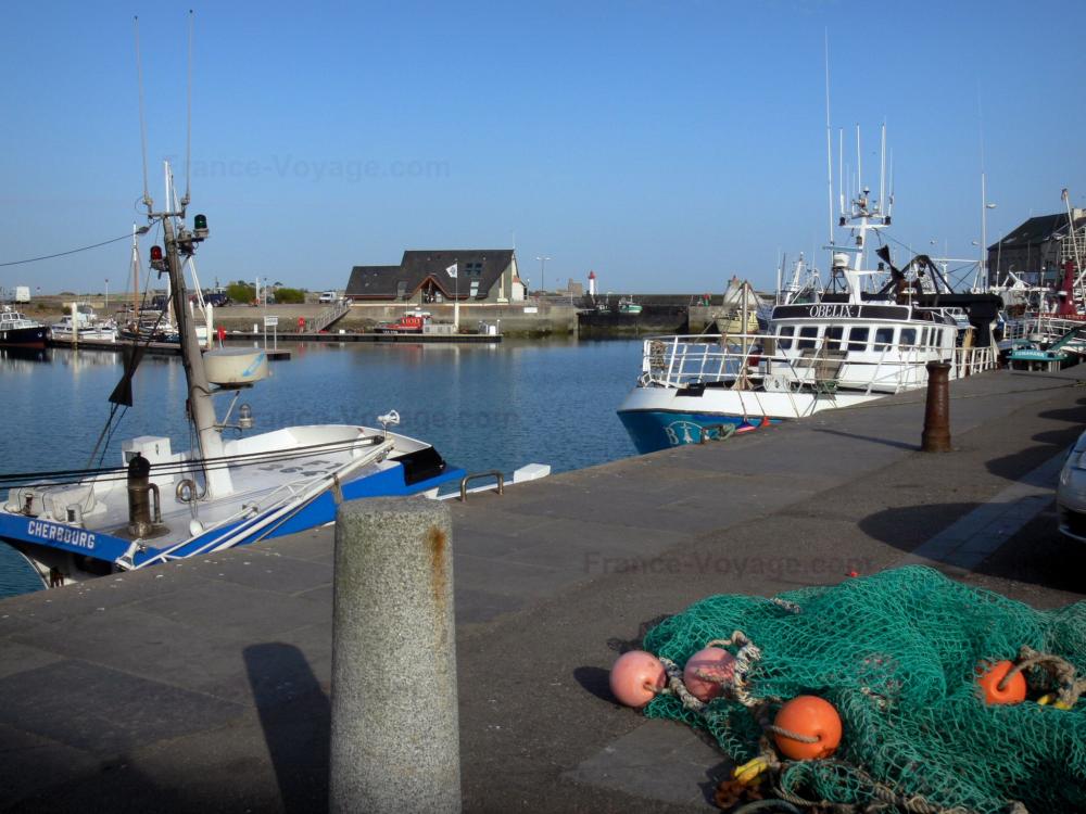 Guide de la Manche - Saint-Vaast-la-Hougue - Port : filet de pêche en premier plan, bateaux amarrés au quai ; dans la presqu'île du Cotentin