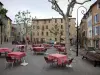 Manosque - Place Marcel Pagnol : terrasse de café, platanes (arbres) lampadaires et maisons de la vieille ville