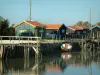 Marennes - Port de la Cayenne : chenal, bateau amarré et cabanes du port ostréicole
