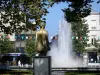 Marmande - Statue de la Pomme d'Amour, fontaine à jets d'eau, arbres et façades de la ville