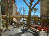 Menton - Petite place colorée avec ses platanes, ses arcades et sa terrasse de café