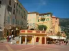 Menton - Tall houses in the colourful facades, but also columns and terrace of restaurant