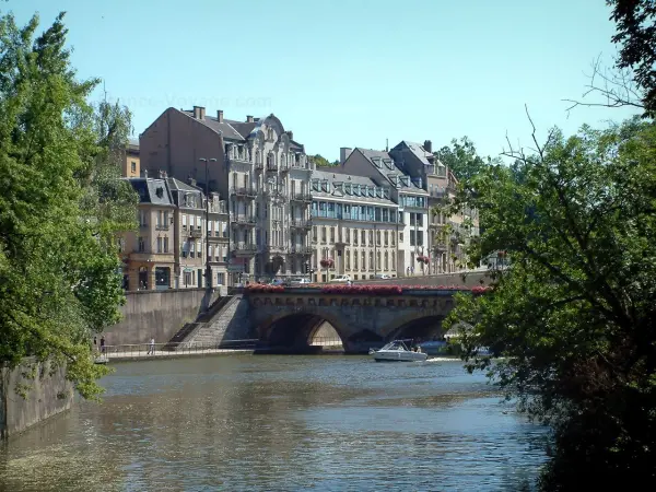 Metz - Moselle river with boats, flower-covered bridge, trees and buildings