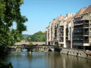 Metz - Moselle river, trees, bridges and buildings with woody balconies decorated with flowers