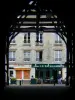 Milly-la-Forêt - Sous la halle, avec vue sur une terrasse de café et une façade de maison du village