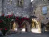 Monpazier - Casas con fachadas decoradas con rosas trepadoras (rosas rojas) y salas de juego de los ángulos de la Place des (plaza central de la mansión), en el Périgord