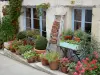 Montaigu-de-Quercy - Façade d'une maison décorée de pots de fleurs