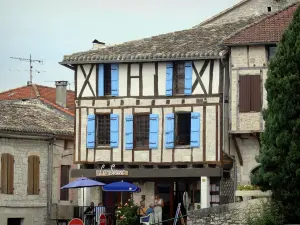 Montaigu-de-Quercy - Cafetería con terraza y entramado de madera, fachada de una casa en el pueblo