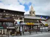 Montgenèvre - Station de ski (station de sports d'hiver et d'été) : clocher de l'église Saint-Maurice avec son fanal, chalet, drapeaux français et commerces