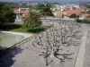 Montpellier - Quartier du Peyrou : place agrémentée d'arbres, de pelouses et de lampadaires avec vue sur les toits de la ville