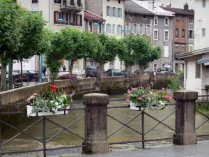 Morez - Barandilla decorado con flores, río Bienne, la línea de árboles, casas y edificios en la ciudad