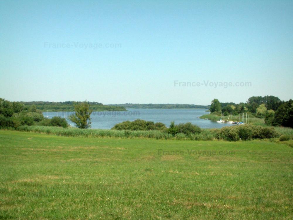 Guide de la Moselle - Paysages de Lorraine - Prairie, arbres et lac avec des bateaux (voiliers)