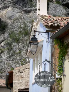 Moustiers Sainte-Marie - Sinal, poste de luz, fachadas da aldeia e parede de pedra