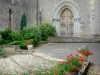 Mugron - Portal of the Saint-Laurent church and flowers arround