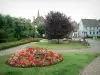 Niederbronn-les-Bains - Parc (jardin) avec fleurs, allée, bancs et arbres, maisons de la station thermale en arrière-plan