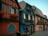 Niedermorschwihr - Maisons à pans de bois aux façades colorées (orange, bleu, rose) et aux fenêtres ornées de géraniums (fleurs)