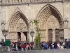 Notre-Dame de Paris cathedral - Portals of the west facade and visitors in the cathedral esplanade
