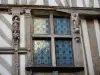 Noyers - Fenêtre et sculptures ornant la façade d'une maison ancienne à pans de bois