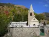 Oisans - Igreja Saint-Ferréol em Huez e montanha coberta de árvores nas cores do outono