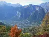 Oisans - Los árboles en los colores del otoño en primer plano con vistas al valle de la Romanche, Le Bourg-d'Oisans y las montañas