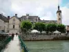 Ornans - Blumengeschmückter Steg überspannend den Fluss Loue, Glockenturm der Kirche Saint-Laurent, Bäume und Häuser der Stadt