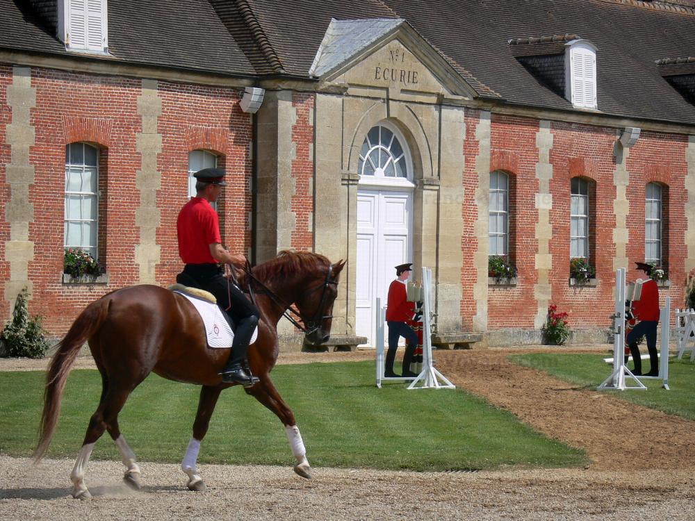 Guide de l'Orne - Haras National du Pin - Jeudis du Pin (spectacle équestre) : cavalier à cheval et façade de l'écurie n°1 ; sur la commune de Le Pin-au-Haras