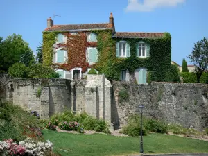 Parthenay - Casa cubierto de viña virgen, paredes, suelo y macizos de flores de la ciudad medieval